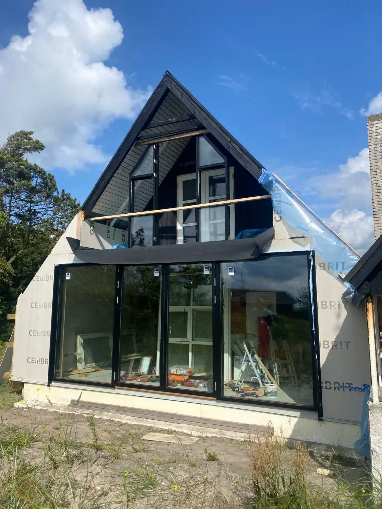 Moderne hus under renovering med store glaspartier