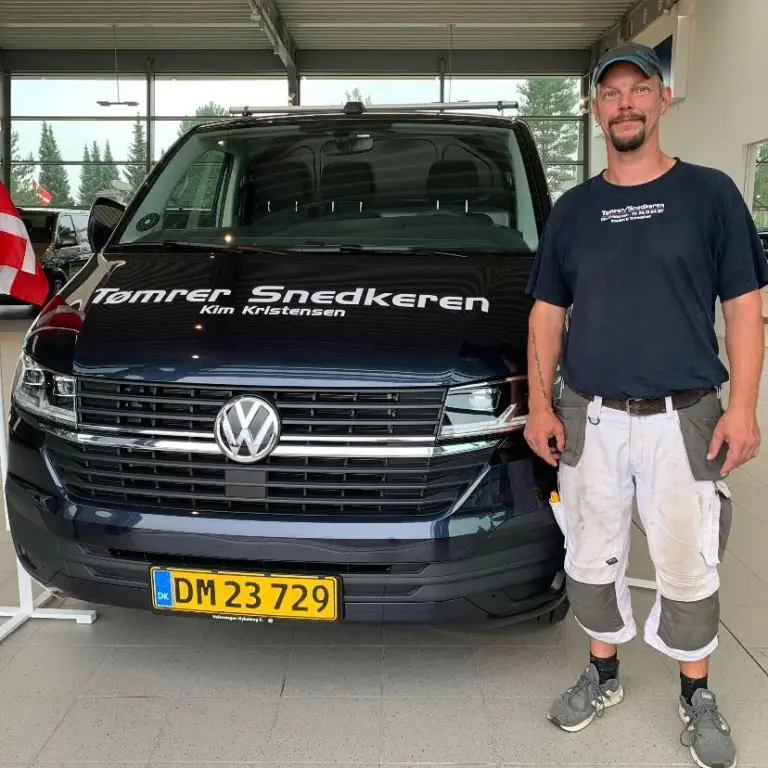 Tømrer foran sort Volkswagen firmabil i showroom