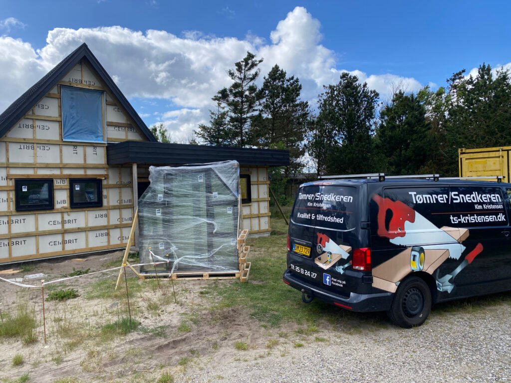 Tømrerarbejde ved nybygget hus med firmabil